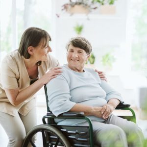 une femme proche d'une femme plus âgée en fauteuil roulant